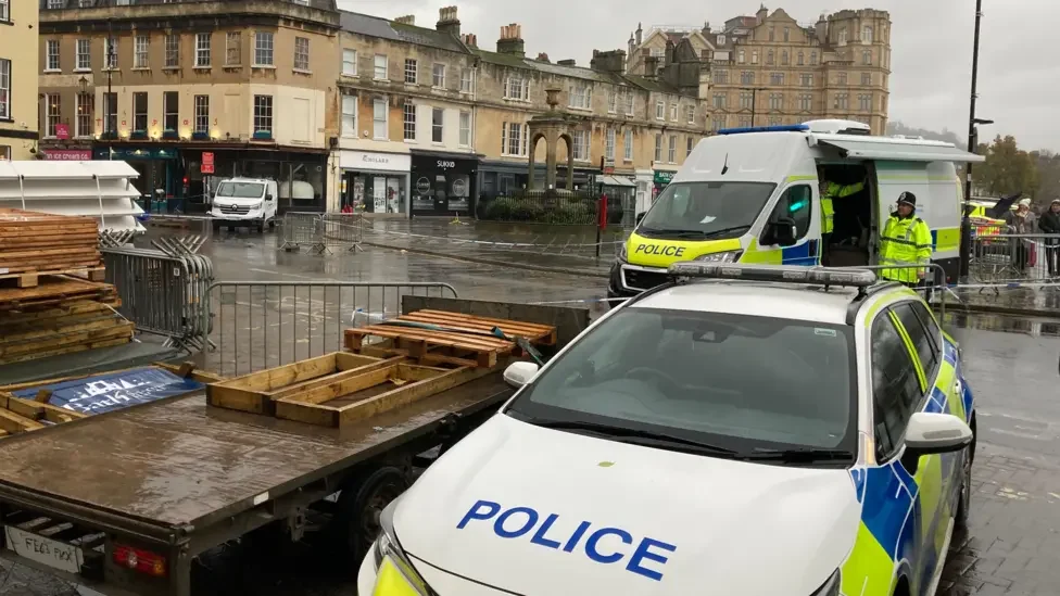 a police car parked next to a flatbed truck