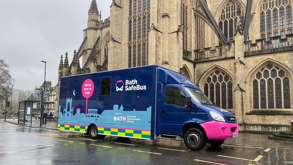 a blue and pink truck parked in front of a building